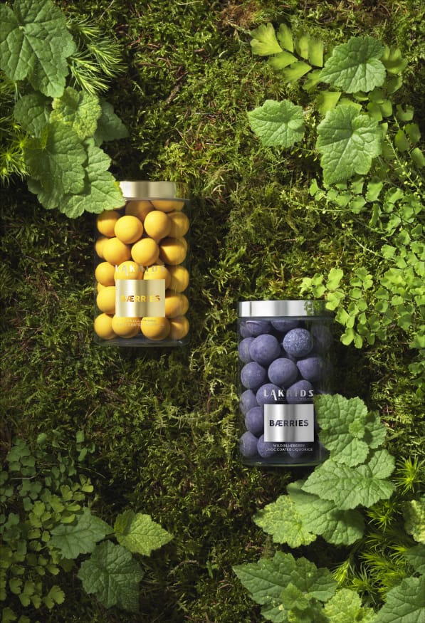 Sommarens smaker av havtorn och blåbär. Två burkar ligger på en bädd av mossa. Foto: Lakrids by Johan Bülow